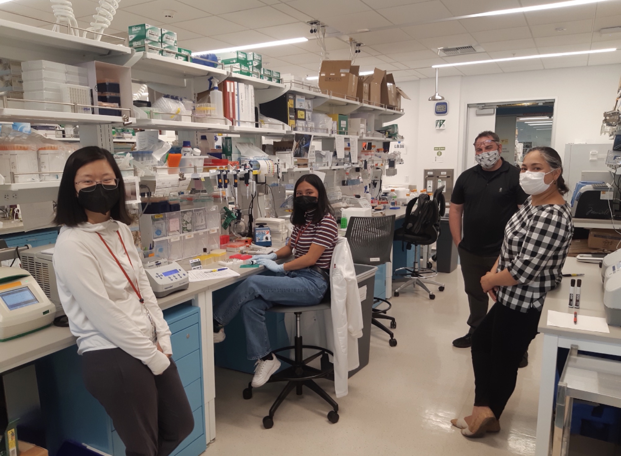 Four lab members at the bench in the Biomedical Innovations Building